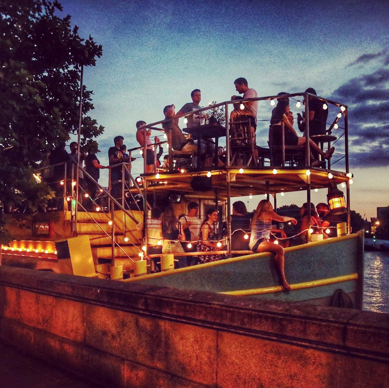 Outdoor event setup at Tamesis Dock with string lights, perfect for social gatherings.