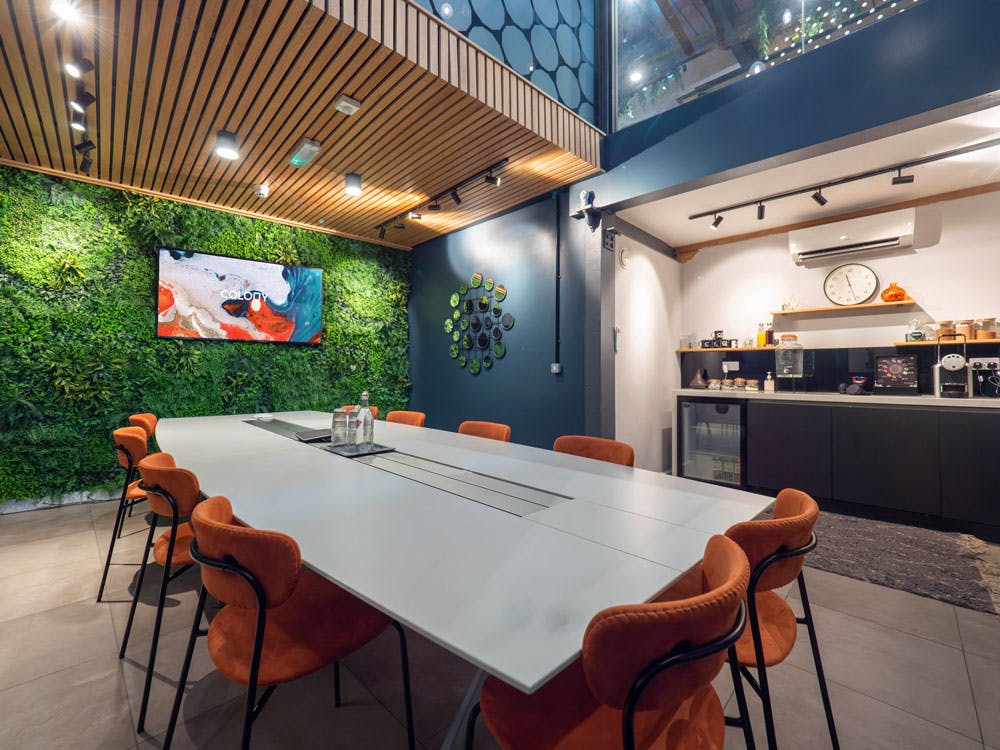 Modern conference room with green wall, ideal for meetings and events.