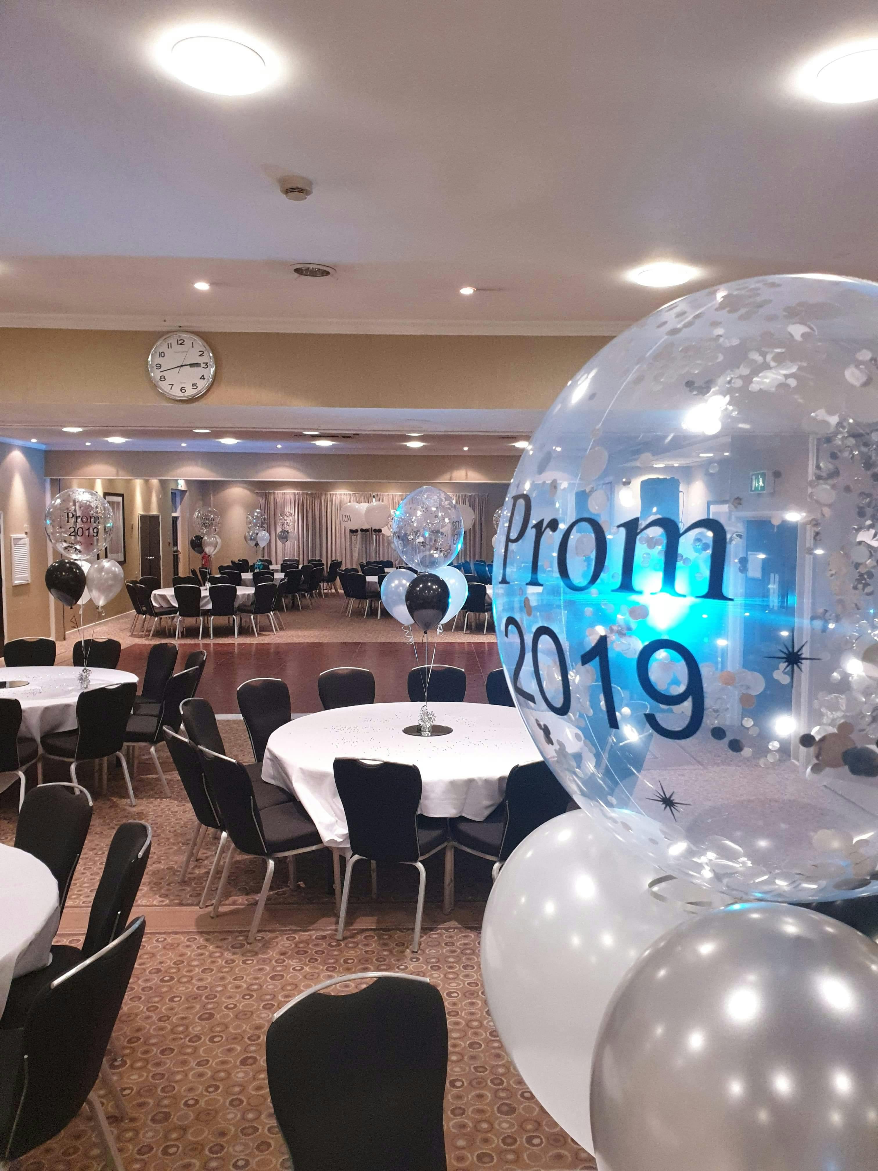 William Duesbury at a prom event in a decorated Holiday Inn space with elegant tables.