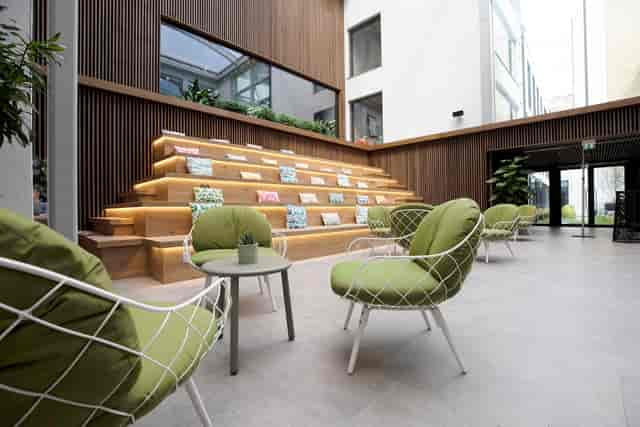 Spitalfields Conservatory event space with stylish green seating and natural light.