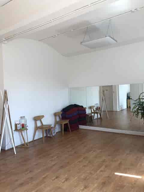 Versatile event space with large mirror, ideal for workshops and yoga sessions.