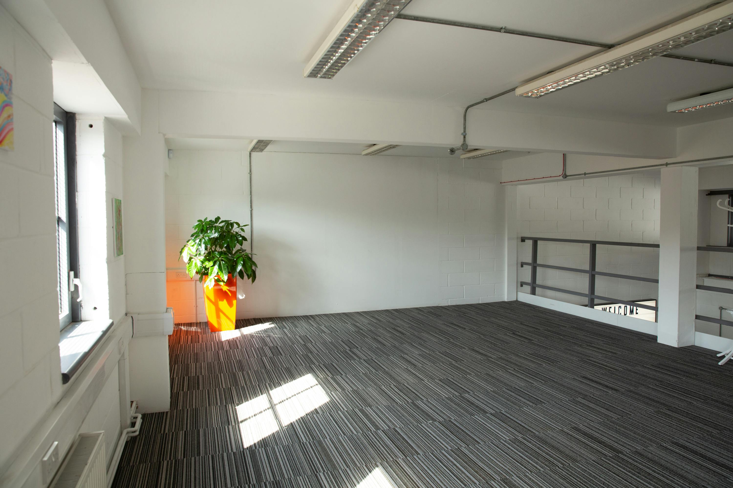 Spacious meeting room with large window, ideal for workshops and brainstorming sessions.