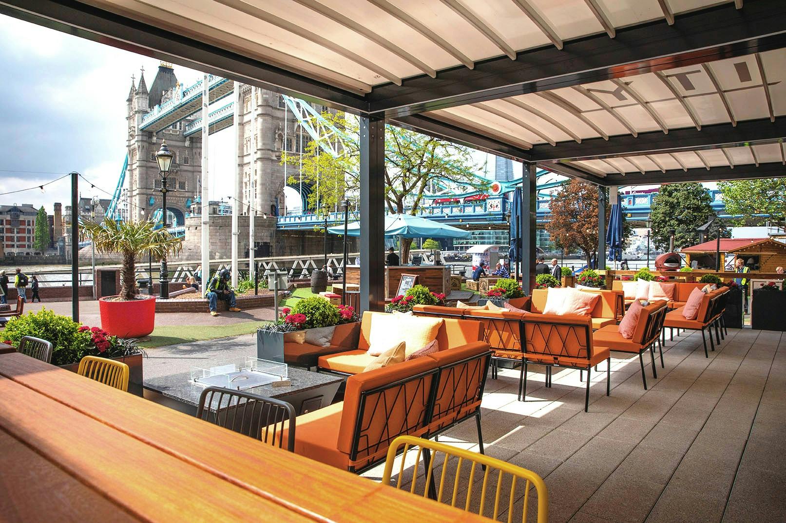 Vibrant outdoor event space with stylish seating and Tower Bridge view in London.