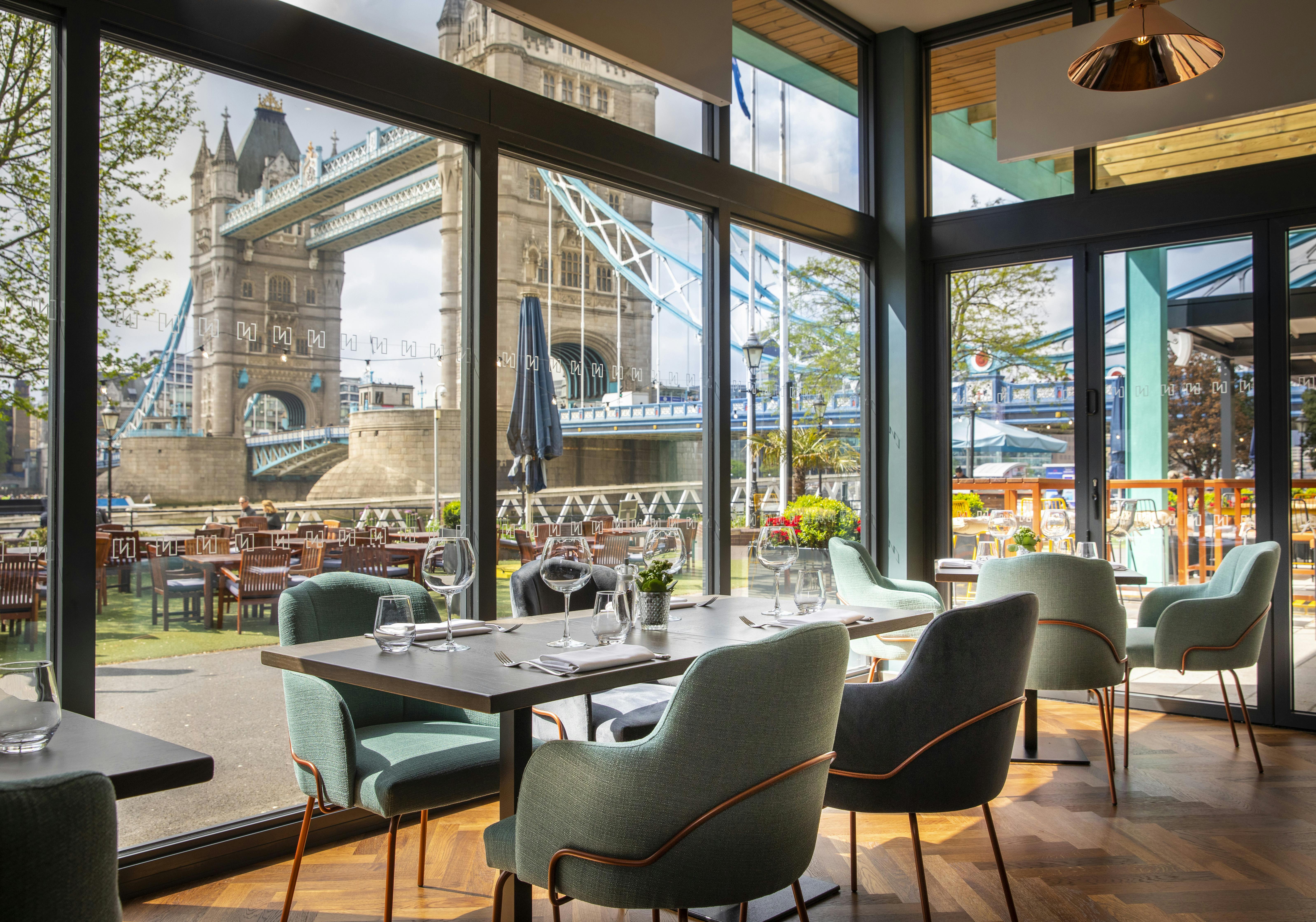 Stylish dining space with large windows and Tower Bridge view, ideal for events in London.