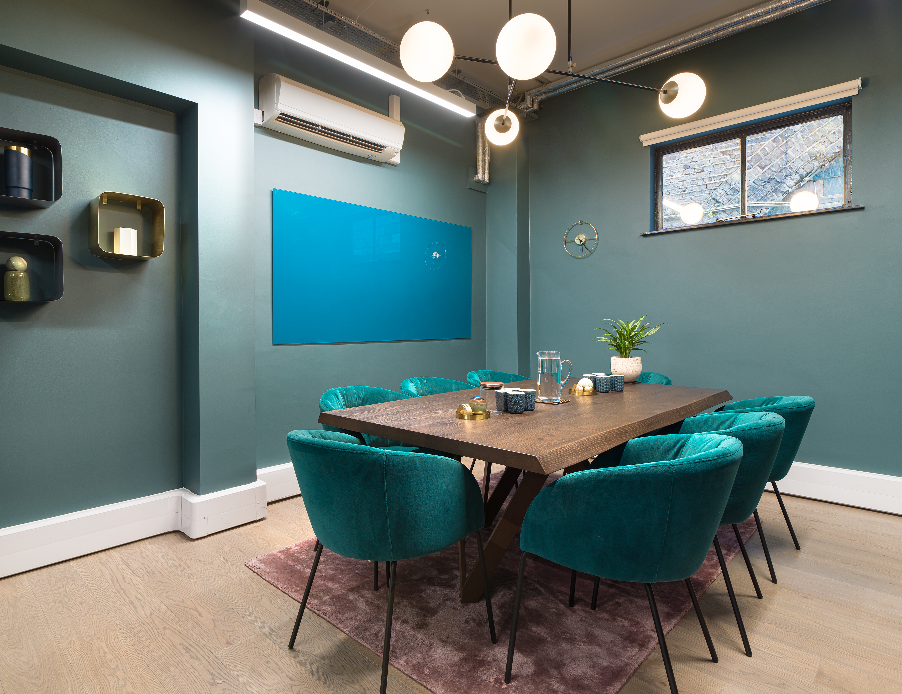 Contemporary meeting room in Uncommon Fulham with teal walls for conferences and workshops.
