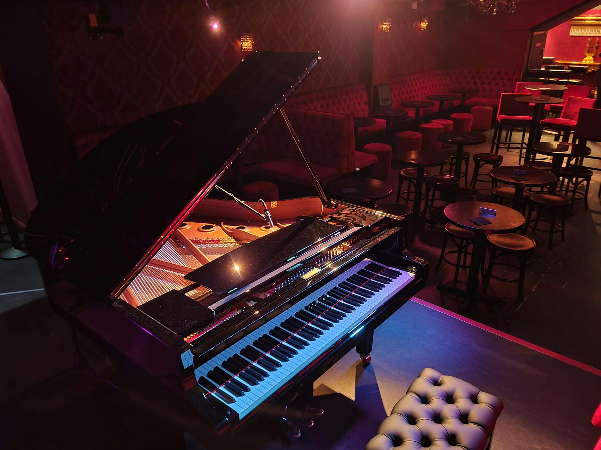 Elegant stage with grand piano at Piano Smithfield for live performances and upscale events.