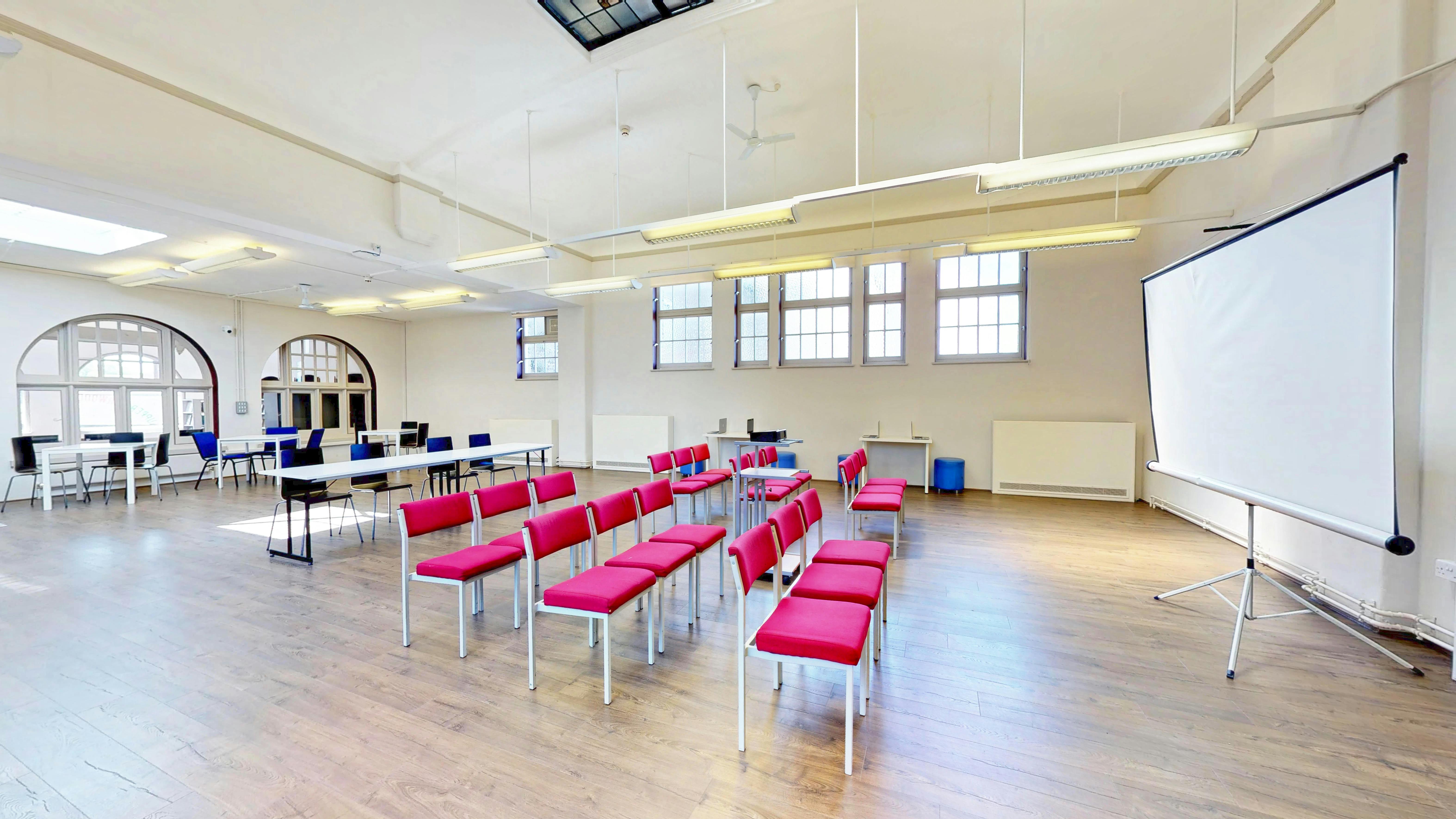 Versatile Burgundy Room with red chairs, ideal for workshops and presentations.