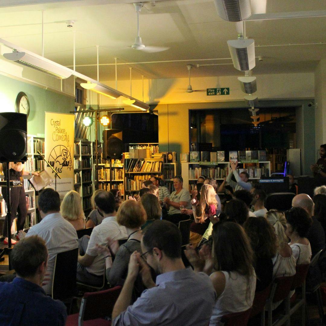 Lively audience in The Burgundy Room, cozy library venue for engaging events.