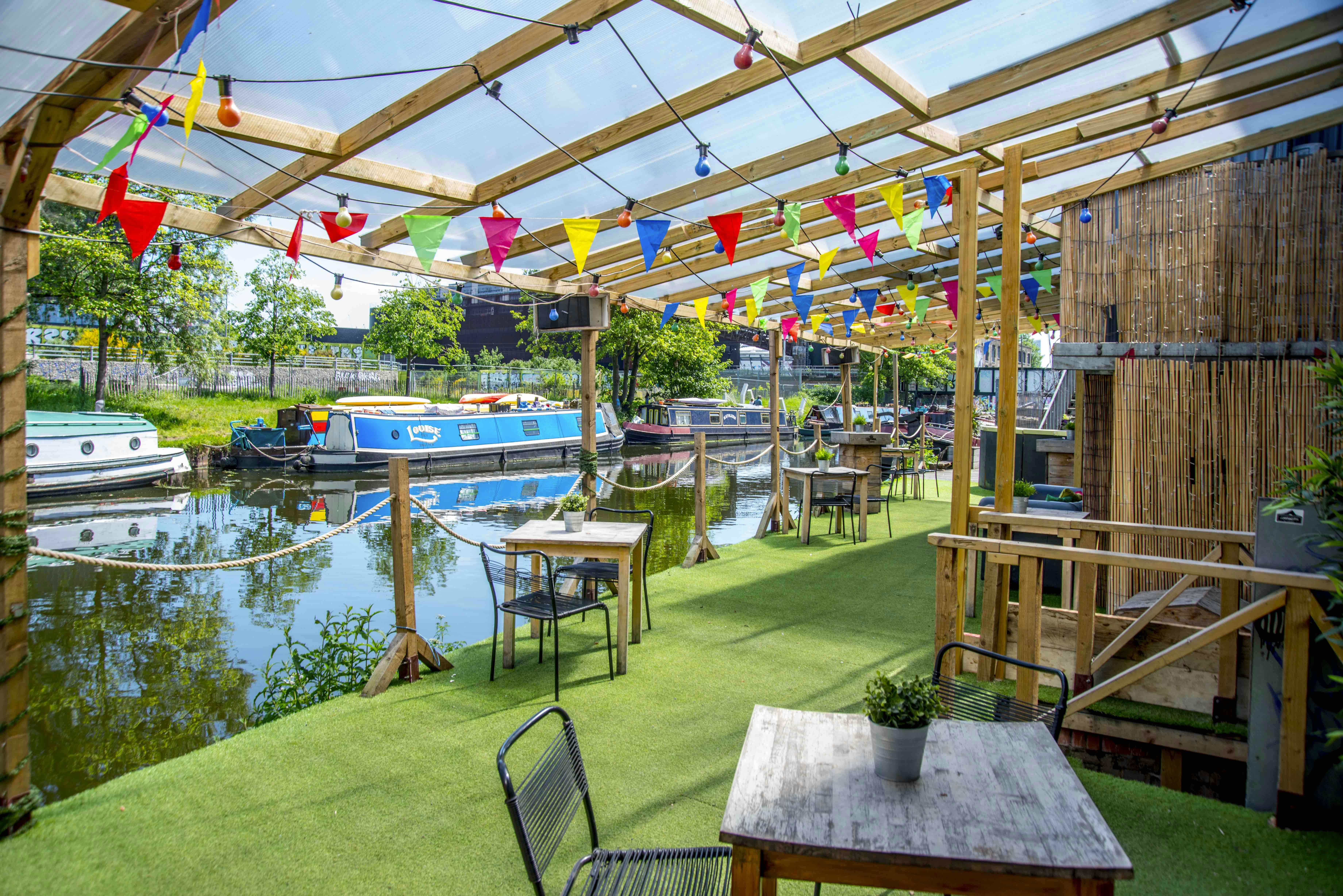 Vibrant outdoor summer party at Studio 9294 with colorful bunting and canal views.