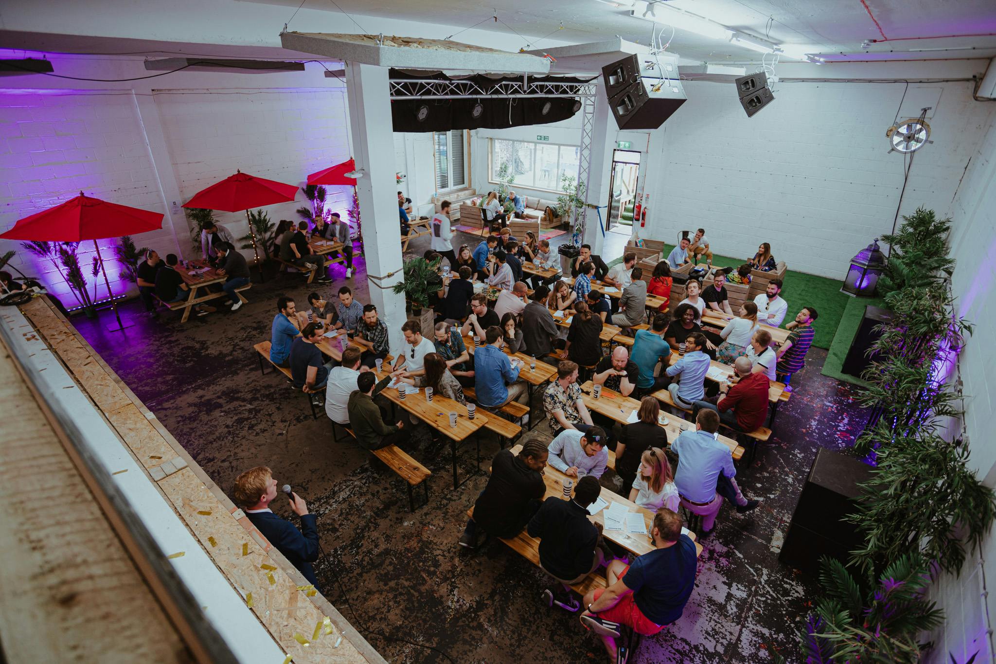 Vibrant summer party at Studio 9294 with colorful lighting and communal seating.