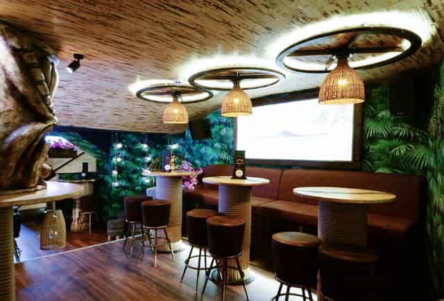 Intimate event space at Laki Kane with warm lighting and lush greenery for gatherings.