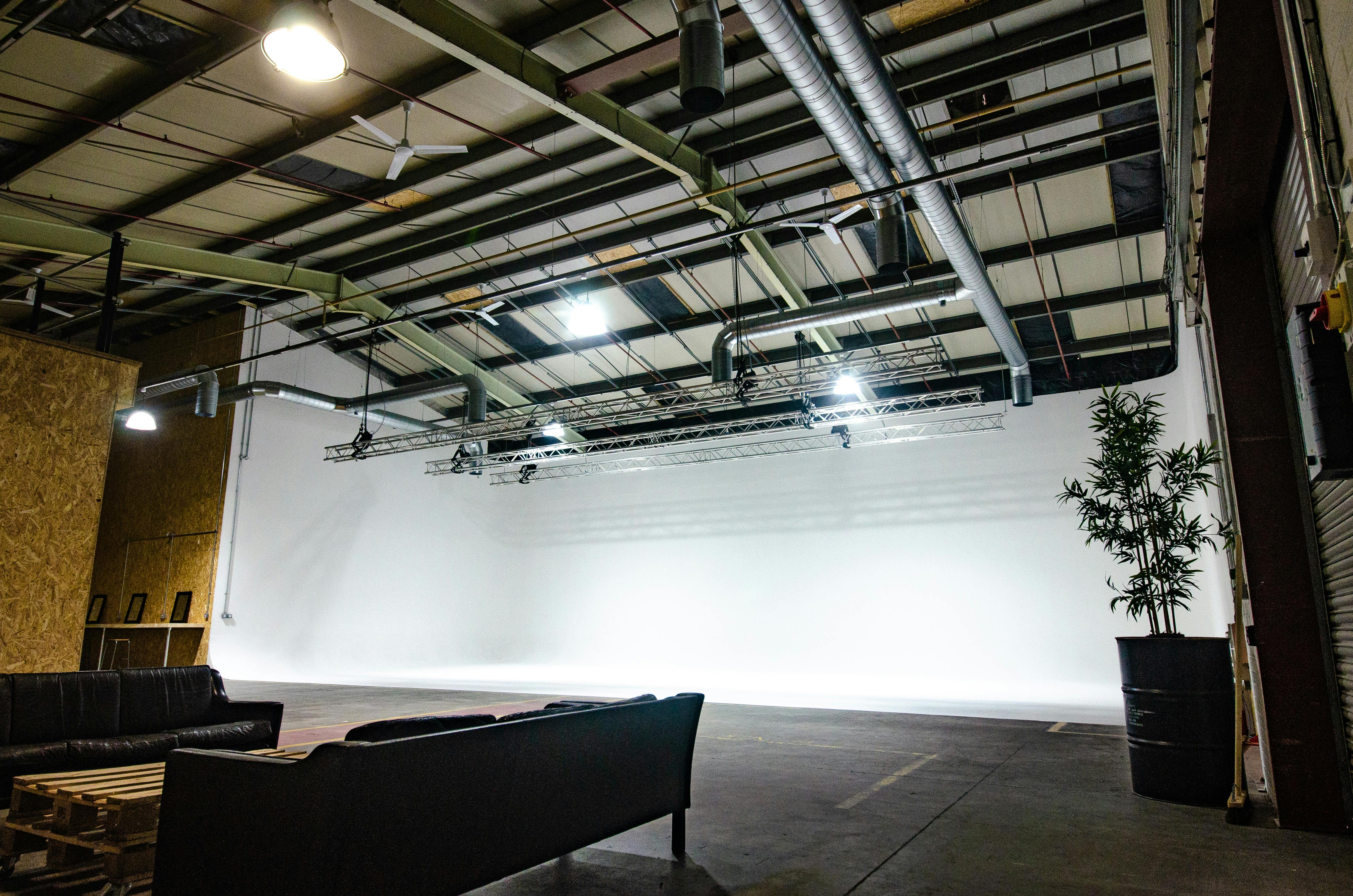 Versatile event space with white backdrop for corporate meetings and creative gatherings.