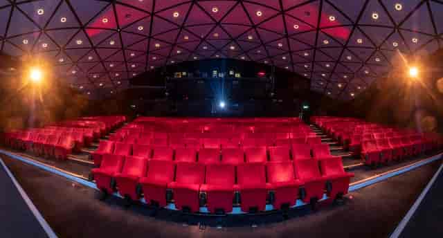 Modern auditorium with red seating, ideal for conferences and film screenings.