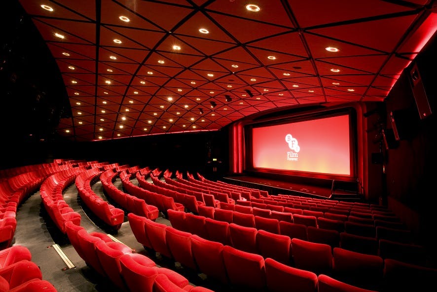 Modern auditorium with plush red seating, ideal for conferences and film screenings.