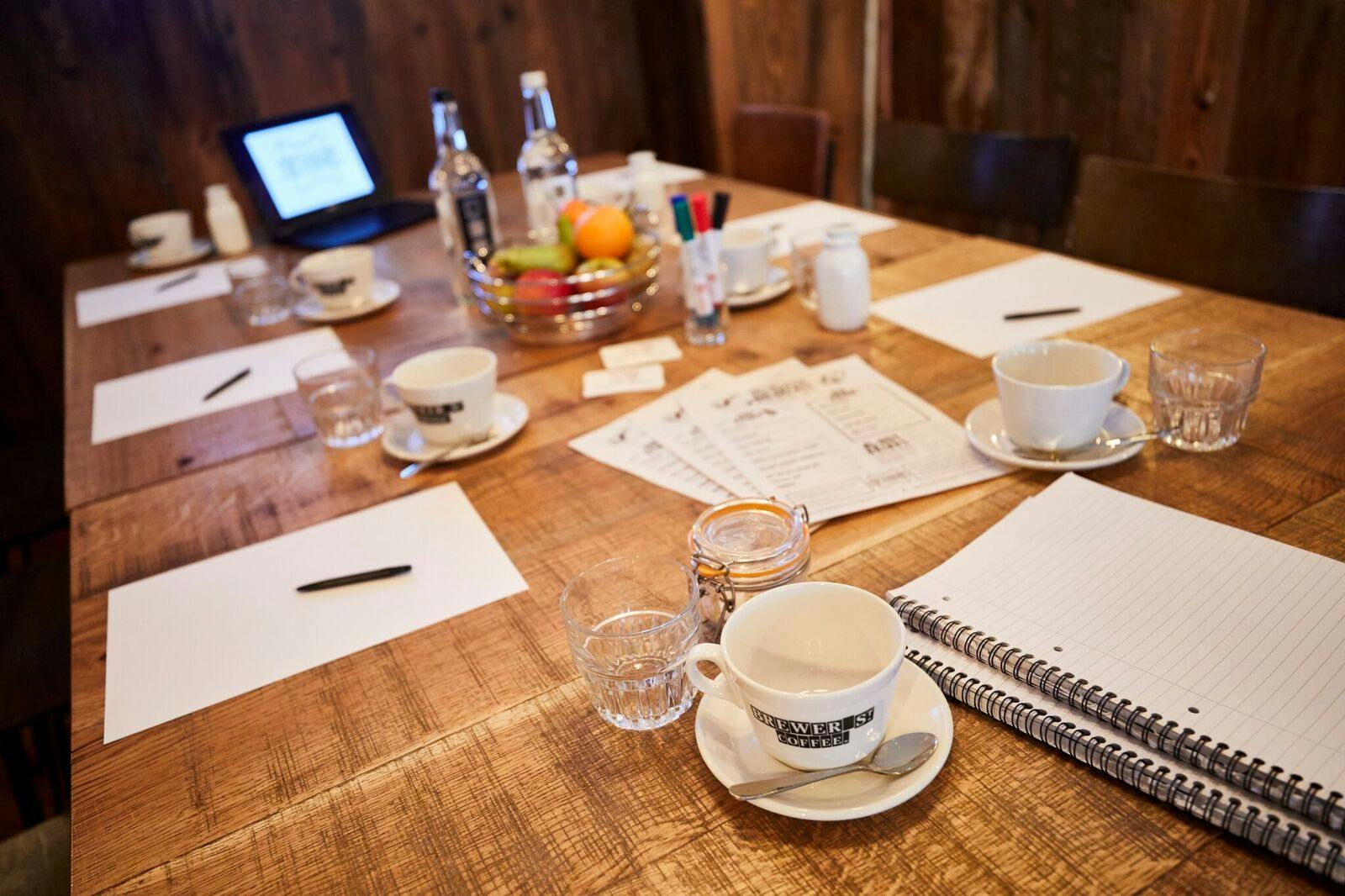 Meeting space with rustic table, coffee, and tech for productive discussions.