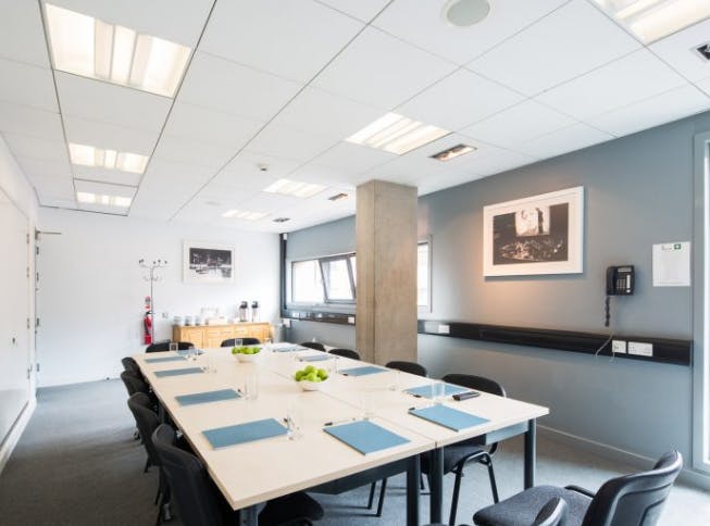 Modern meeting room with long table, ideal for workshops and presentations.