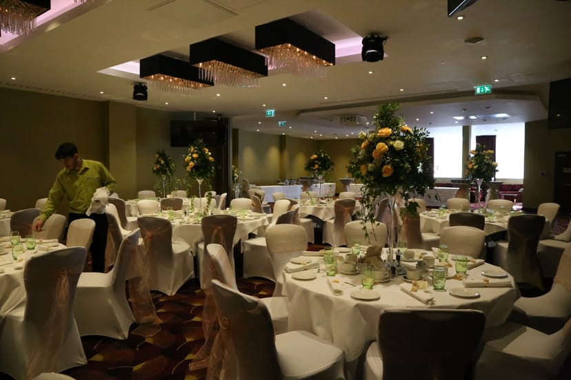 Elegant wedding banquet hall at Holiday Inn Kensington, featuring floral centerpieces.