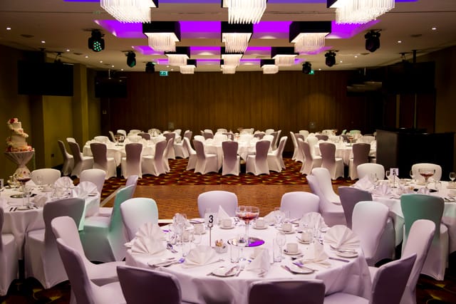 Elegant wedding banquet room at Holiday Inn Kensington, featuring stylish round tables.