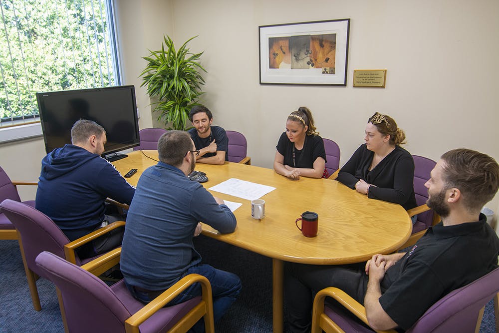 Bonner Suite meeting room with professionals collaborating around a round table.