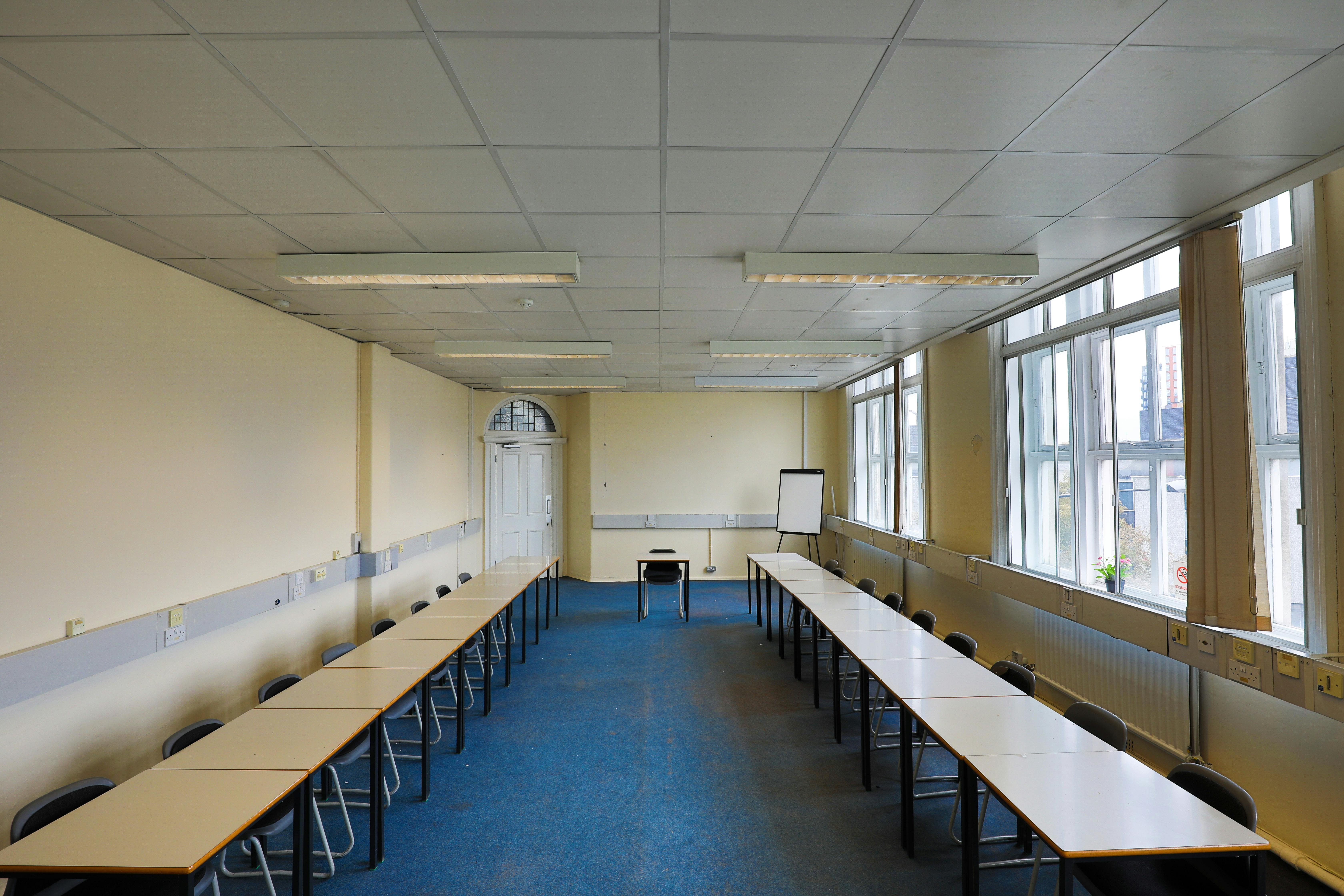 Spacious U-shaped conference room with natural light for workshops and training sessions.