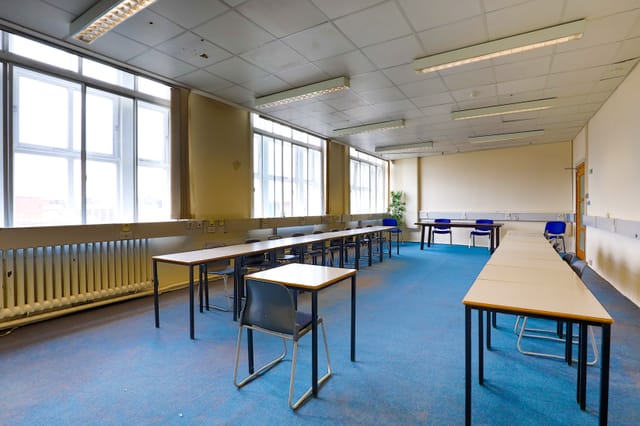 Spacious conference room with natural light, ideal for workshops and training sessions.
