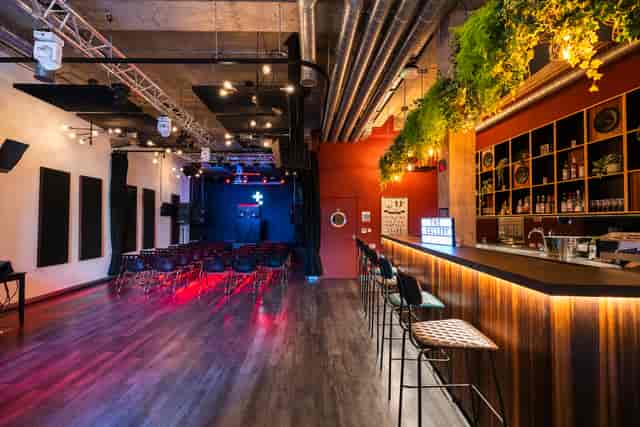 Versatile event space in The Gallery, Tileyard London with sleek bar and stage.