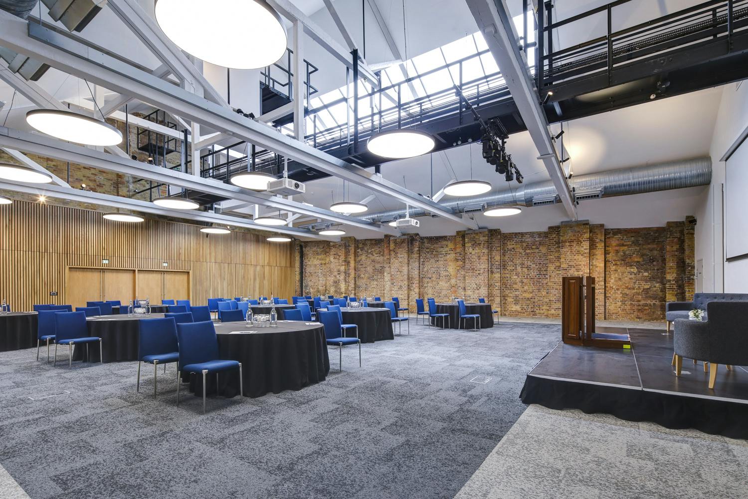 Main Hall at 10 Union St., modern event space with round tables for conferences and meetings.