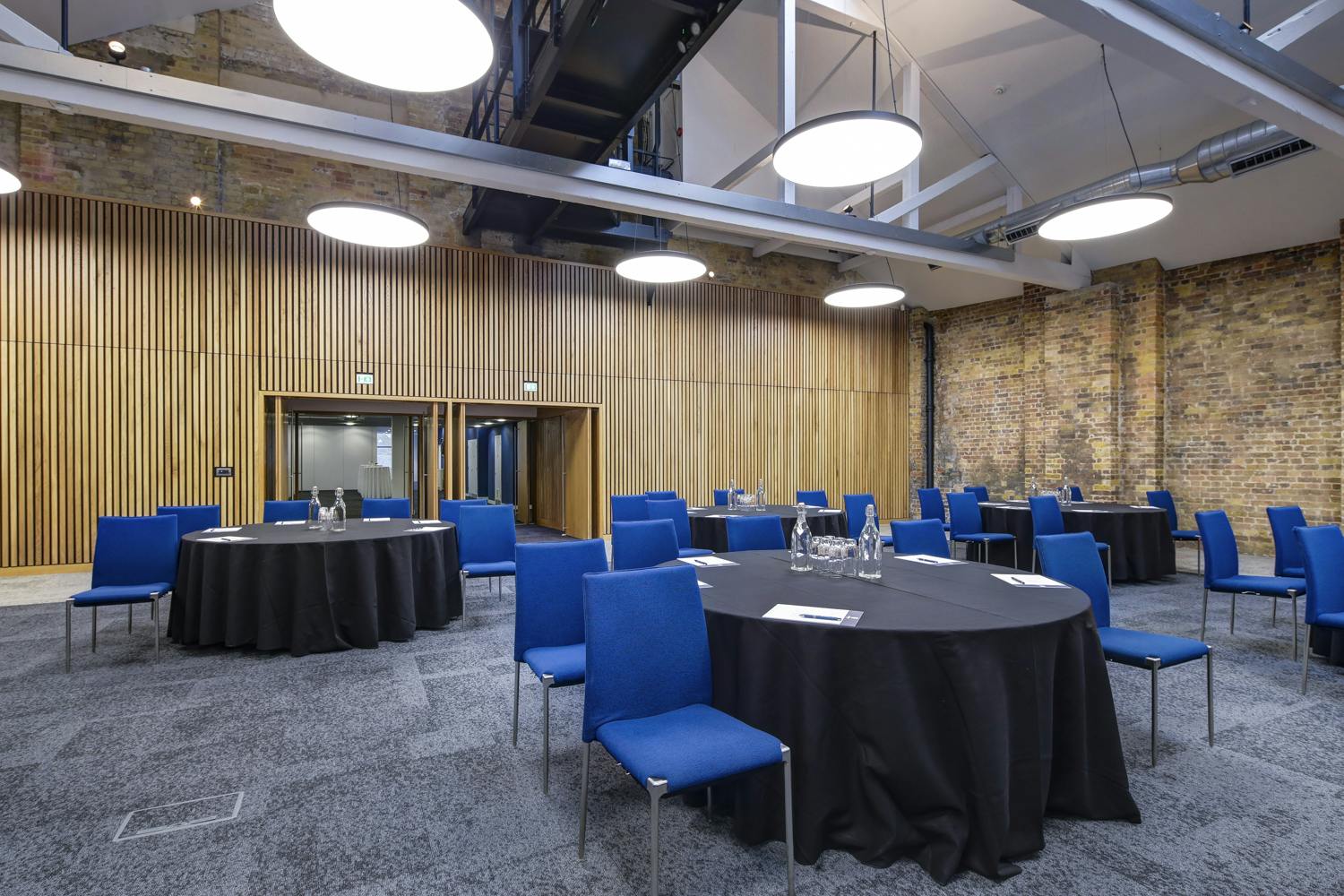 Main Hall at 10 Union St. with round tables, ideal for meetings and events.