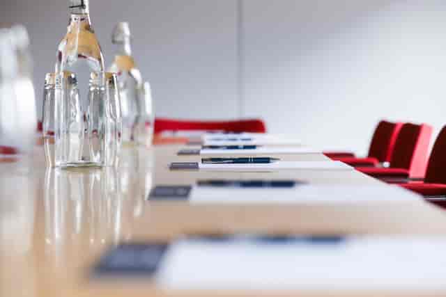 Meeting space at 101 Union St with long table, water bottles, and red chairs.