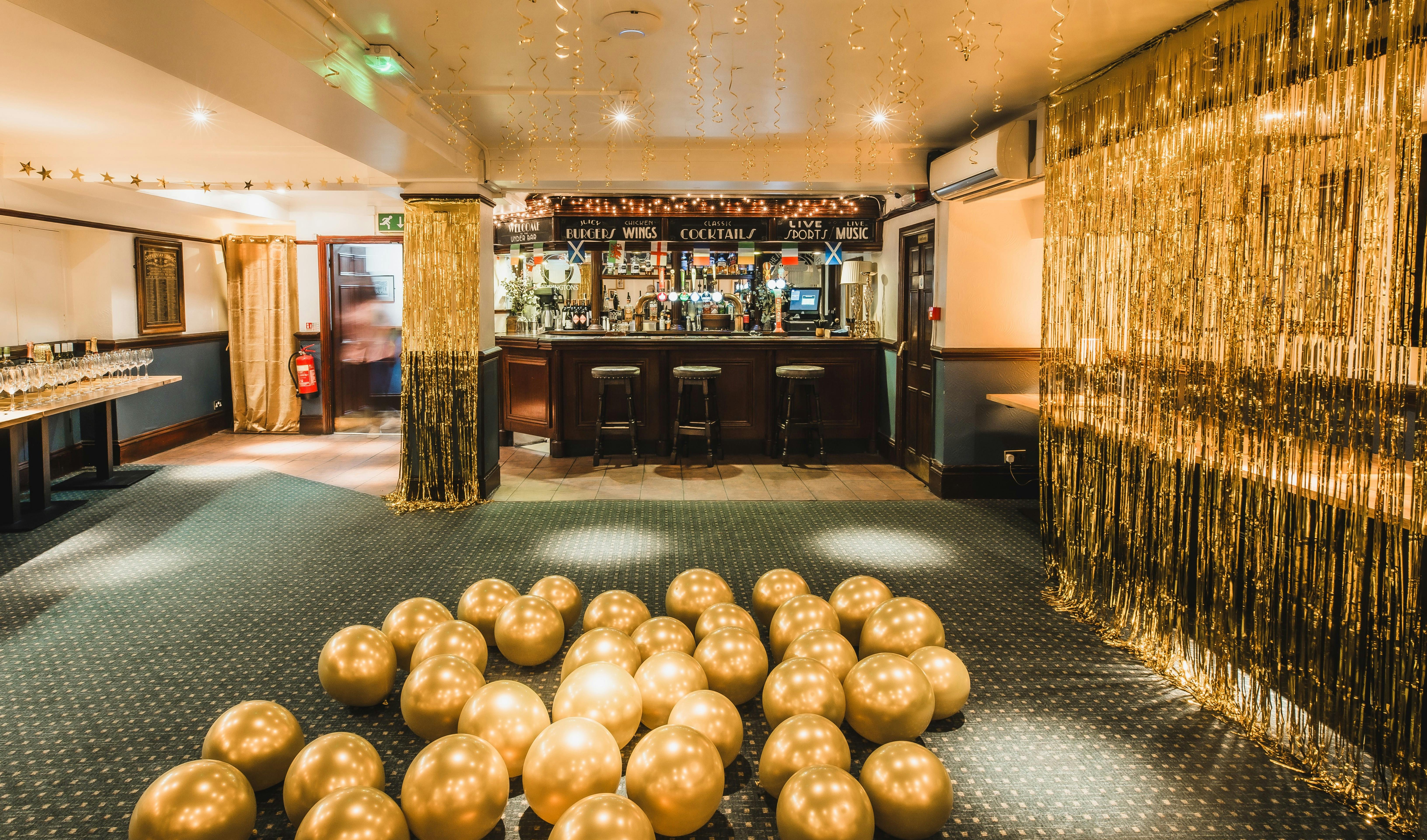 Private function room with golden balloons, ideal for celebrations and corporate events.