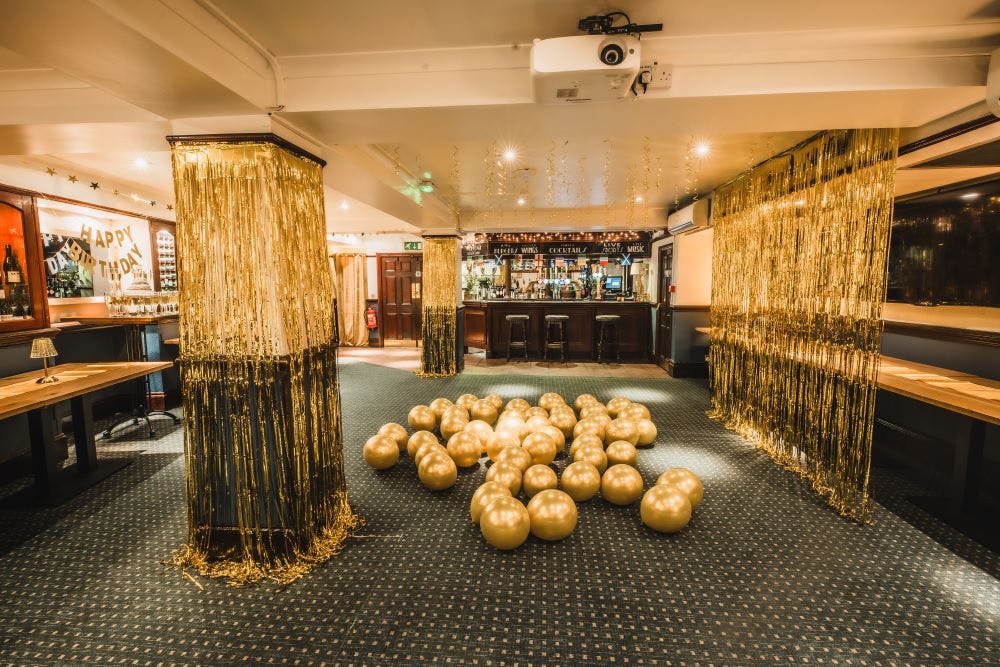 Private function room with golden balloons, ideal for celebrations and corporate events.