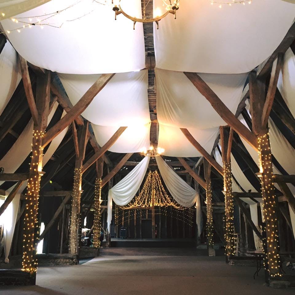 Elegant event space in The Manor Barn with rustic beams, ideal for weddings and gatherings.