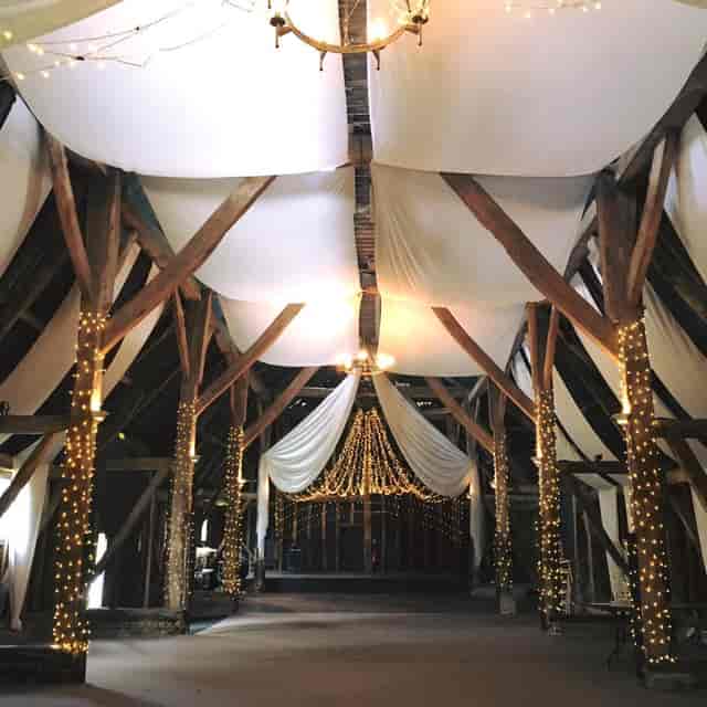 Elegant event space in The Manor Barn with rustic beams, ideal for weddings and gatherings.
