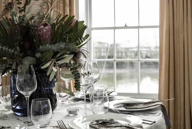 Elegant dining table with floral centerpiece in Commodores Room, perfect for events.