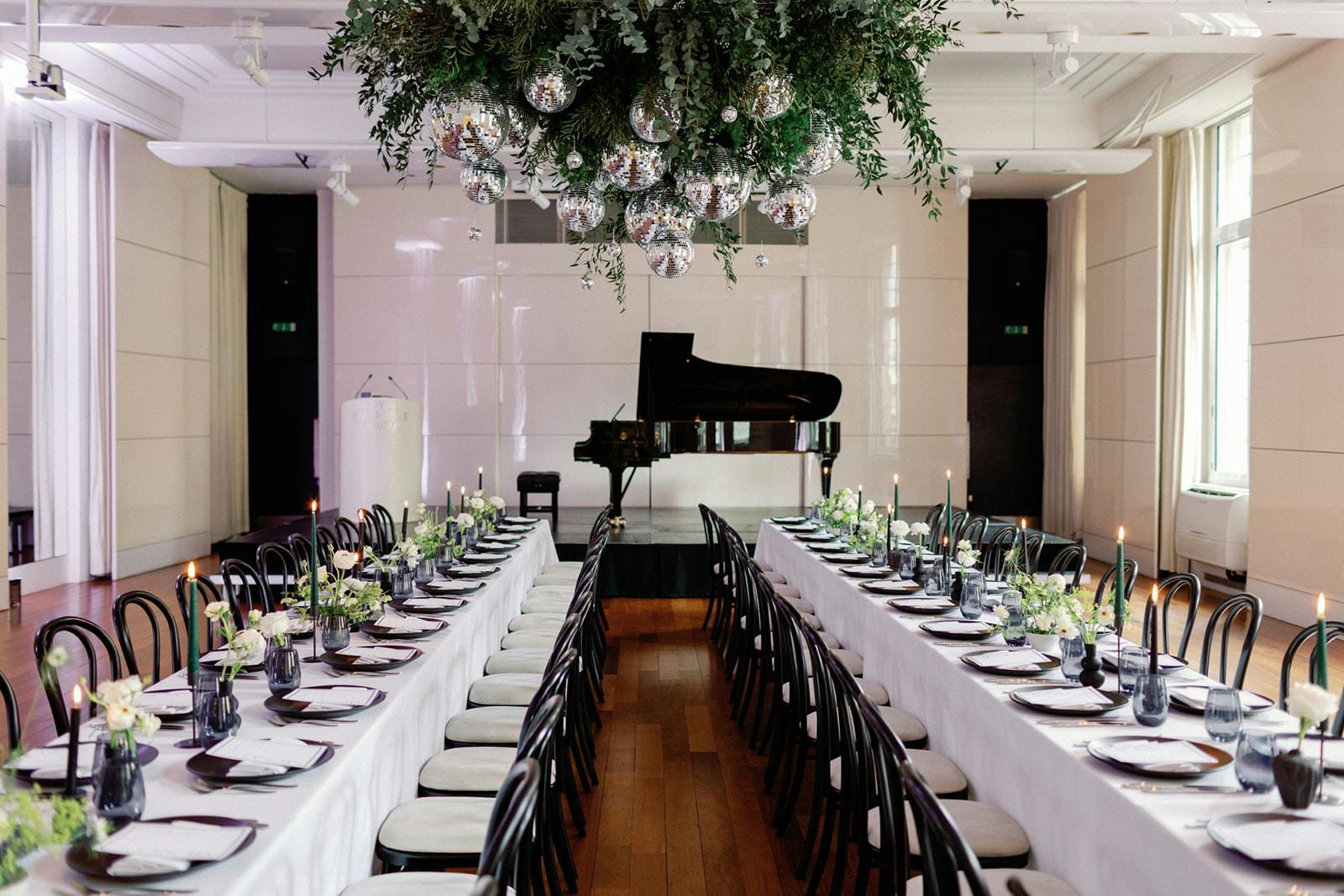 Elegant Christmas party setup with greenery, candles, and grand piano at Six Park Place.