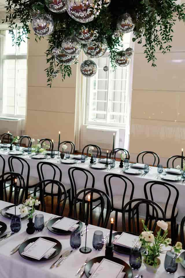 Minimalist Christmas party tablescape with black bentwood chairs at Six Park Place event venue.