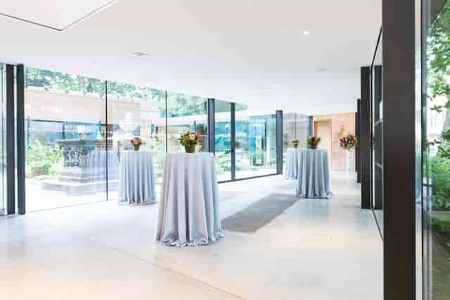 Elegant event space with high-top tables and lush garden at Garden Museum.