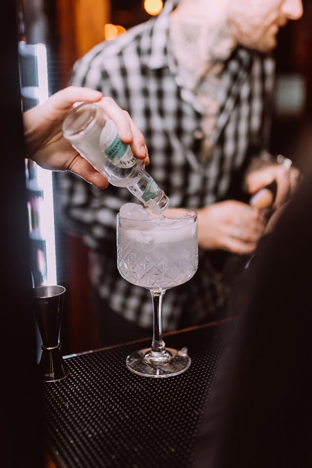 Bartender crafting a cocktail at The Fireplace, ideal for event catering and mixology.