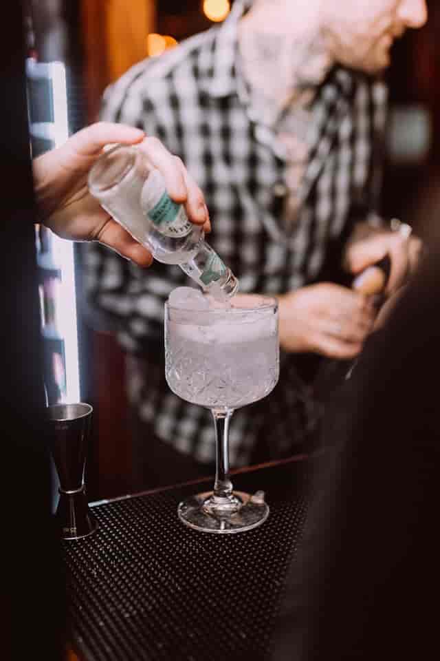 Bartender pouring cocktail at The Fireplace, enhancing event catering experience.