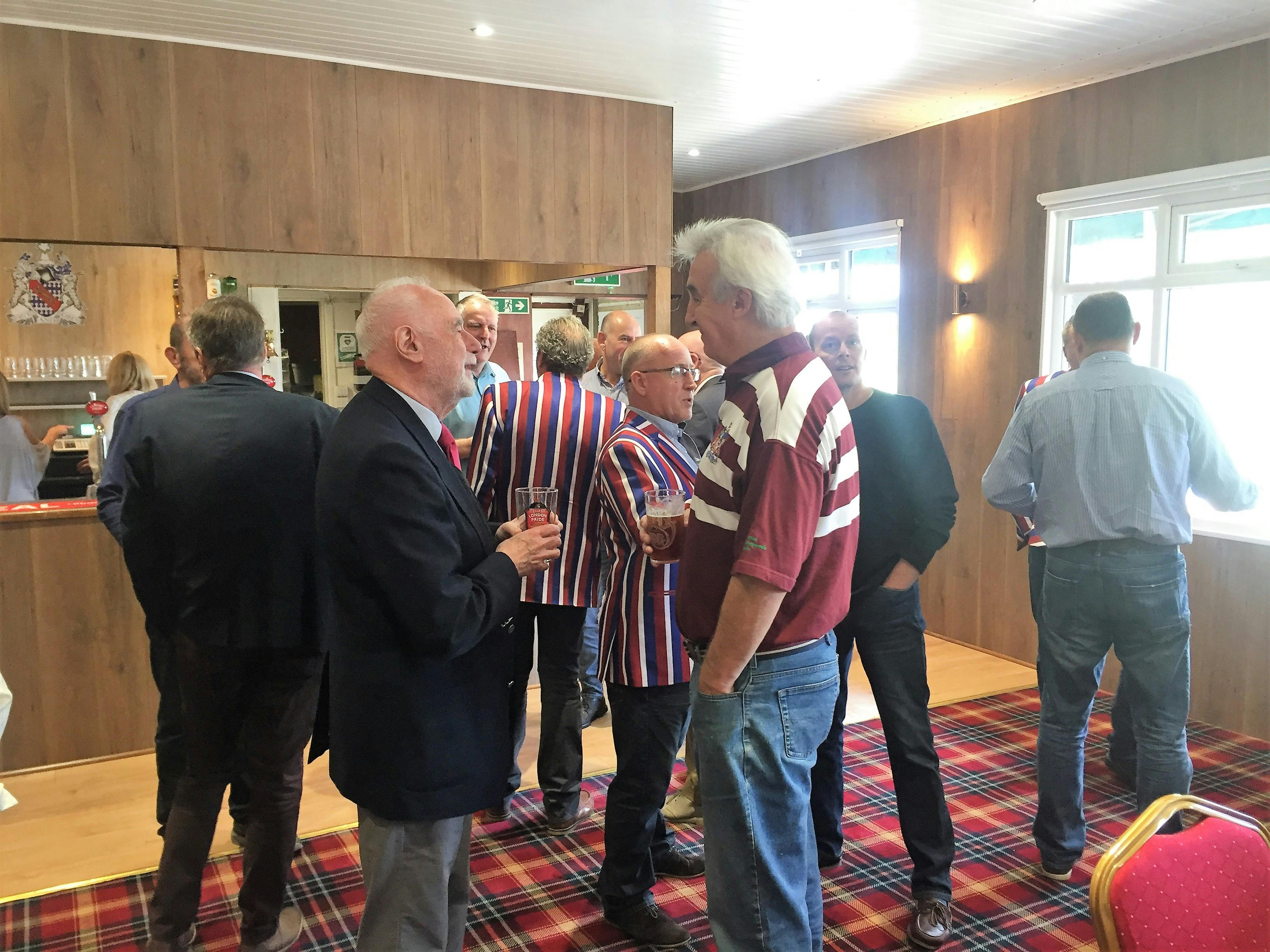 Lively networking event at Clubhouse, featuring striped jackets and casual interactions.