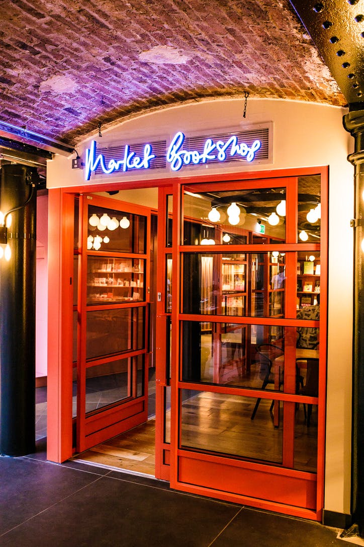 Vibrant entrance of The Market Bookshop with bold red doors, perfect for creative events.