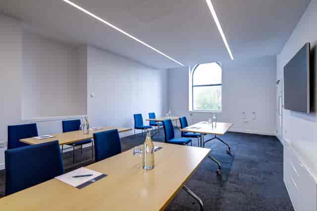 Modern meeting room 303 at 10 Union St. with blue chairs for events and collaboration.