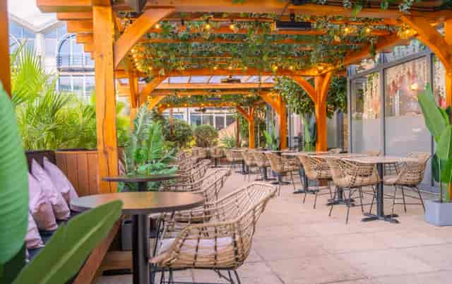 Outdoor event space with wooden pergolas, ideal for networking and gatherings.