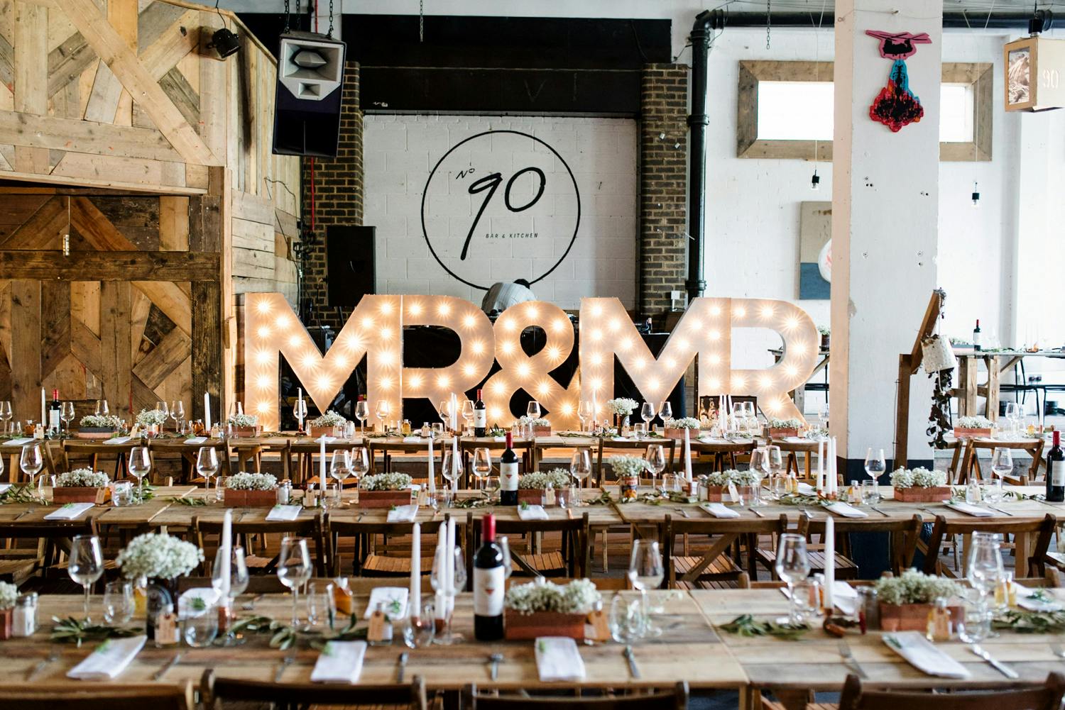 Rustic wedding reception at 90 Bar & Kitchen with "MR & MR" sign and elegant decor.