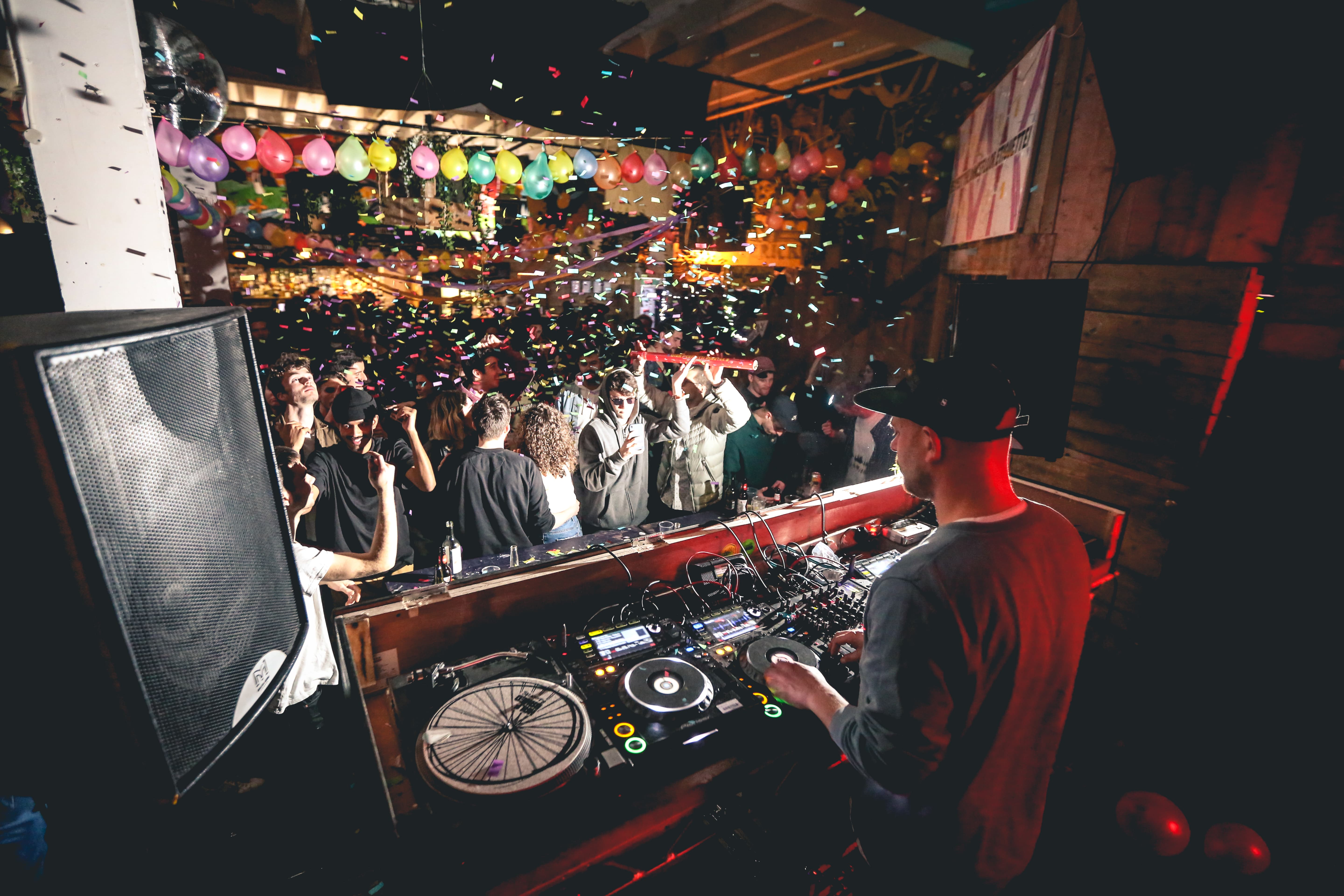 DJ at 90 Bar & Kitchen with colorful balloons for vibrant party atmosphere. - Banner