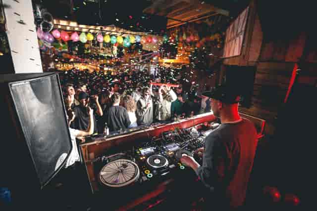 DJ at 90 Bar & Kitchen with colorful balloons for vibrant party atmosphere.
