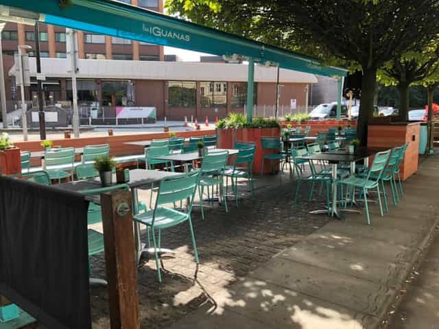 Outdoor dining area at Las Iguanas Cardiff with turquoise chairs, ideal for networking events.