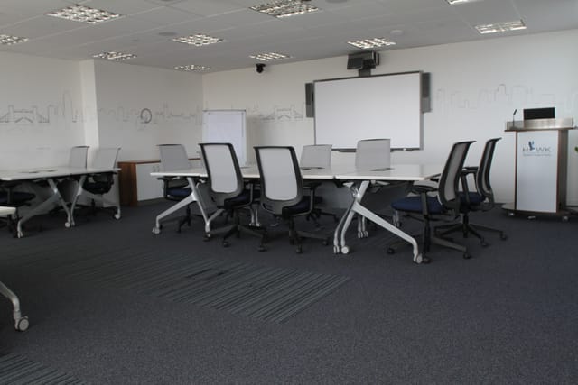 Modern meeting room with modular tables, ideal for workshops and brainstorming sessions.