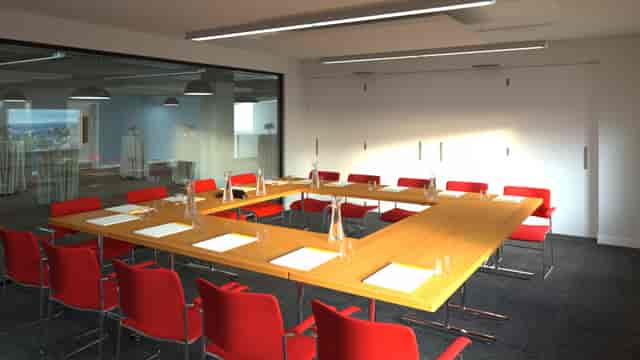 Modern conference room with large table and red chairs, perfect for meetings and collaboration.