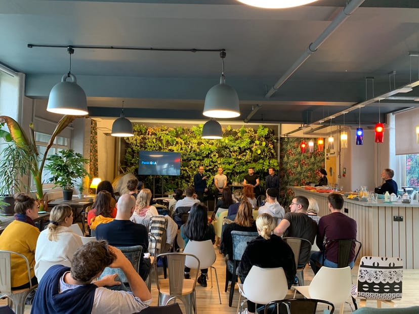 Vibrant Use.Cafe event space with greenery for panel discussions and workshops.